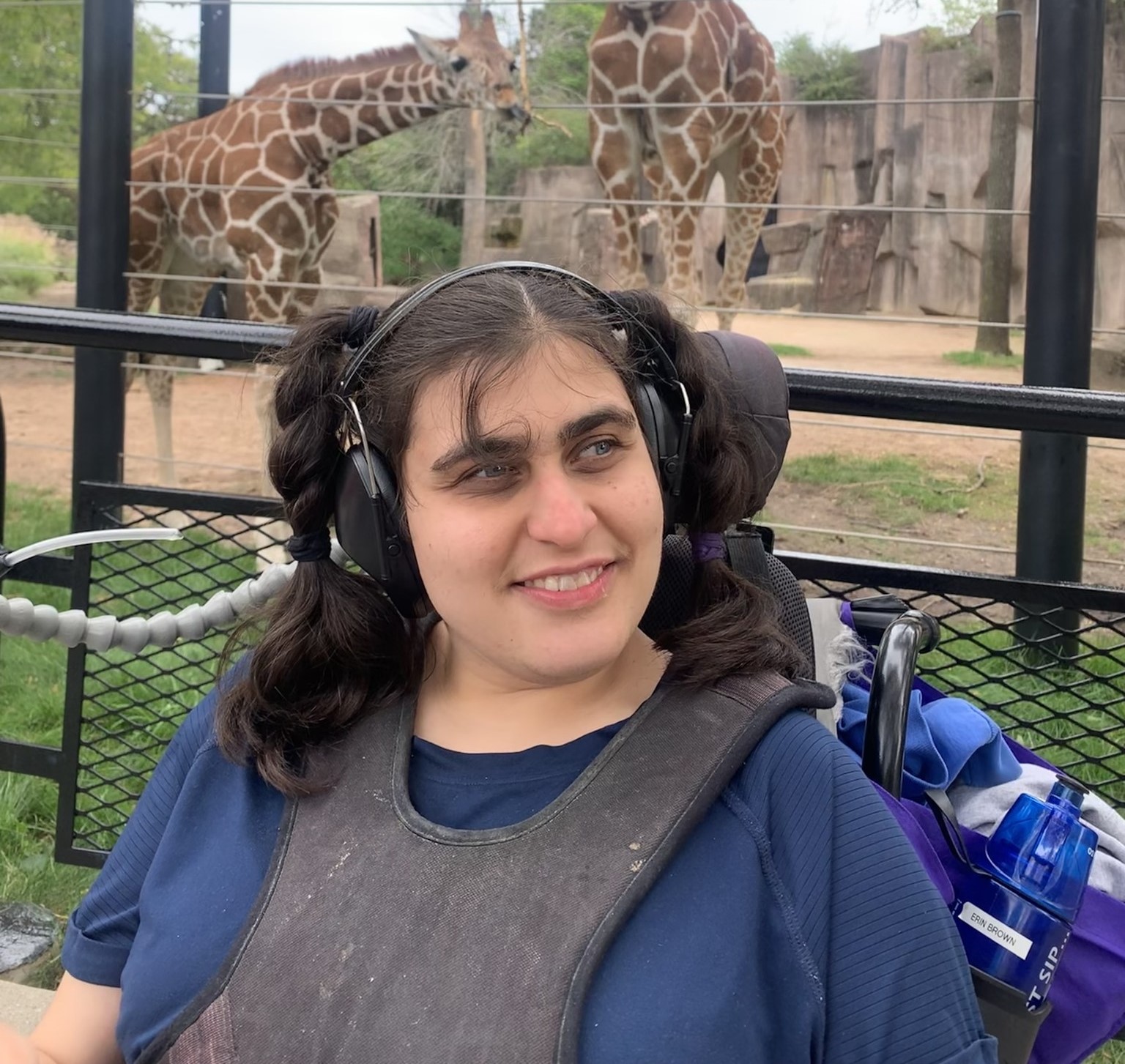 A photo of CEL member posing my giraffe at the zoo.