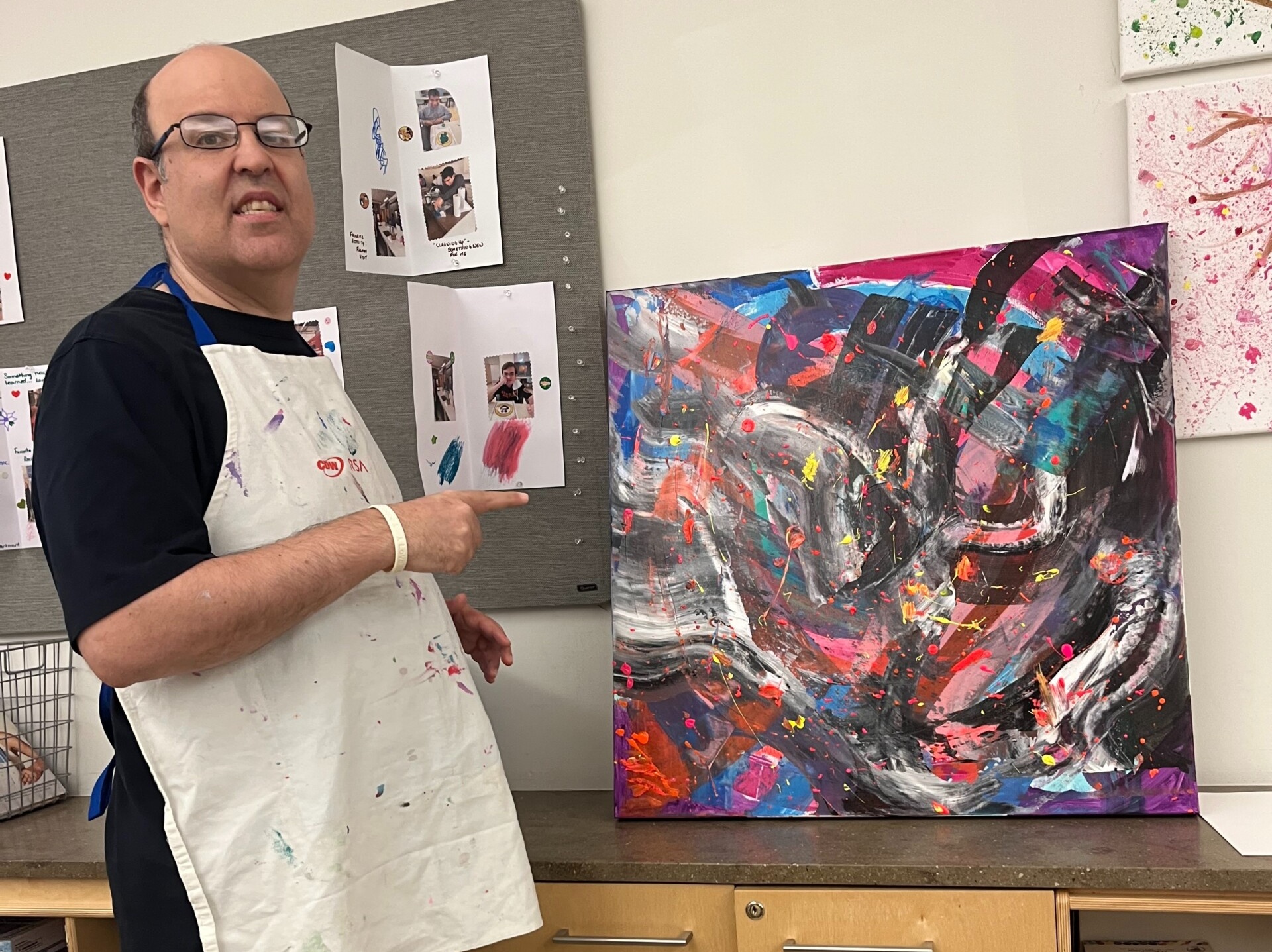 A picture of CEL member Howie proudly showing off his artwork.