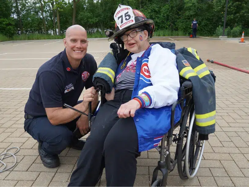 CEL member smiling alongside a firefighter during community day.