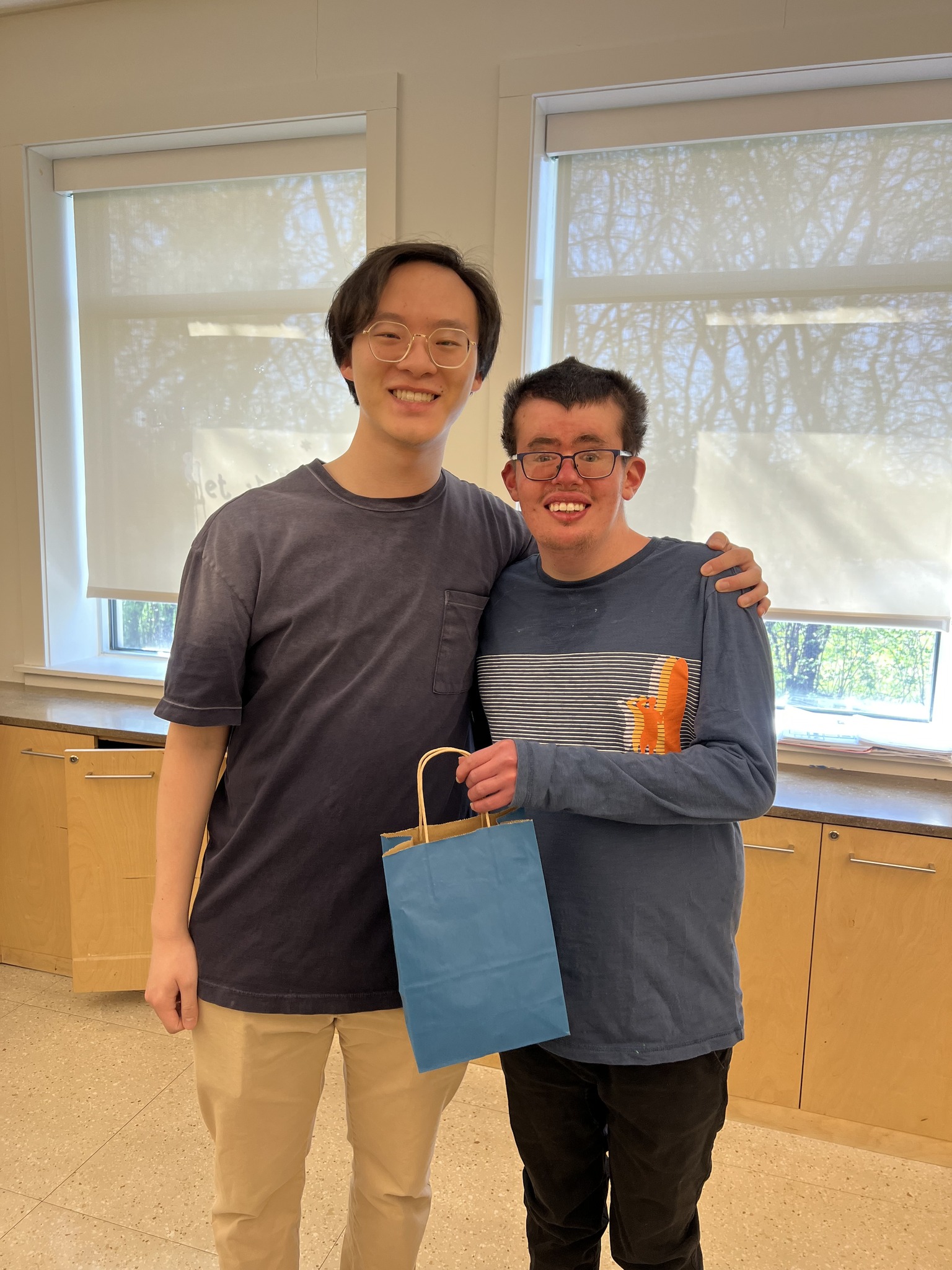 A CEL member smiling with volunteer as they give volunteer their volunteer appreciation week gift.