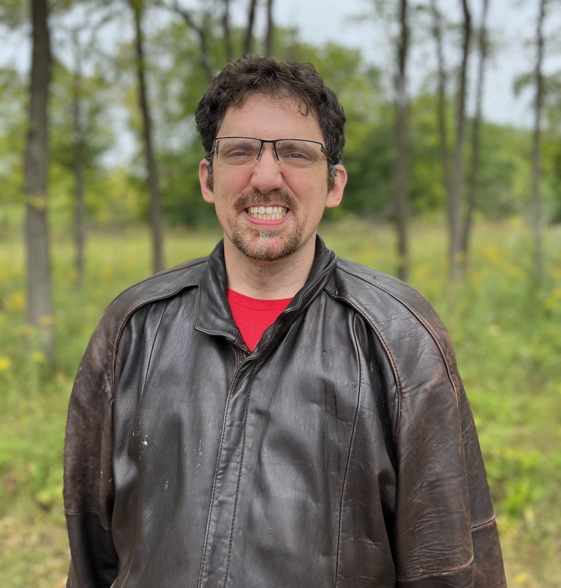 Catalyst member John smiling on forest preserve trail.